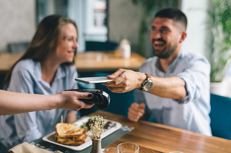Couple paying for diner with phone.