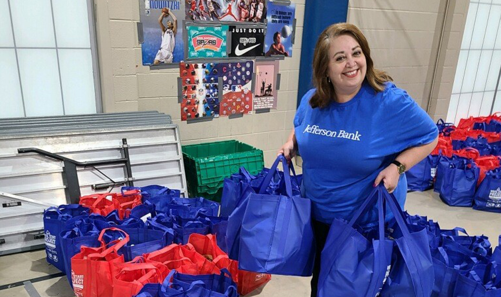 Rachel Trevino (Trust) helping load bags of school supplies intended  for teachers in Edgewood ISD and Southwest ISD through the United Way’s Write  Start Project.