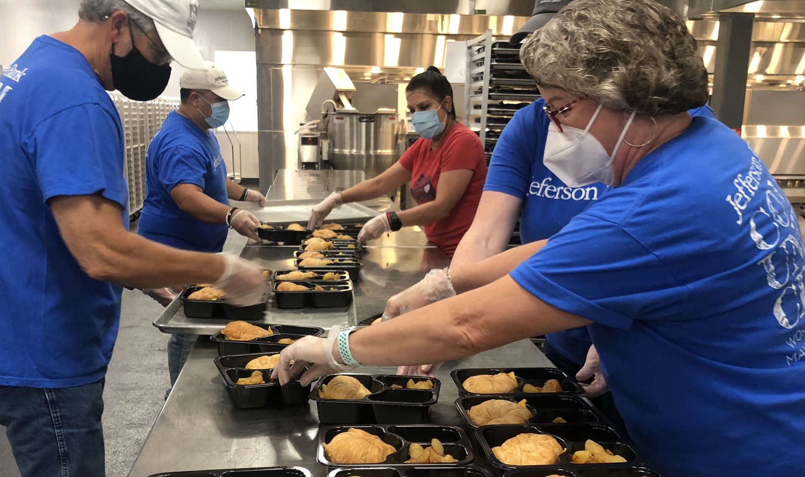Volunteering at the San Antonio Food Bank preparing lunch trays for  children and seniors who participate in various programs throughout San  Antonio. pictured left to right: Max Vega (Mortgage), Larry Ratcliff (IT), Liz Garza,  Kathy Cunningham (Accounting), and Sharna Zimmerman (Mortgage)