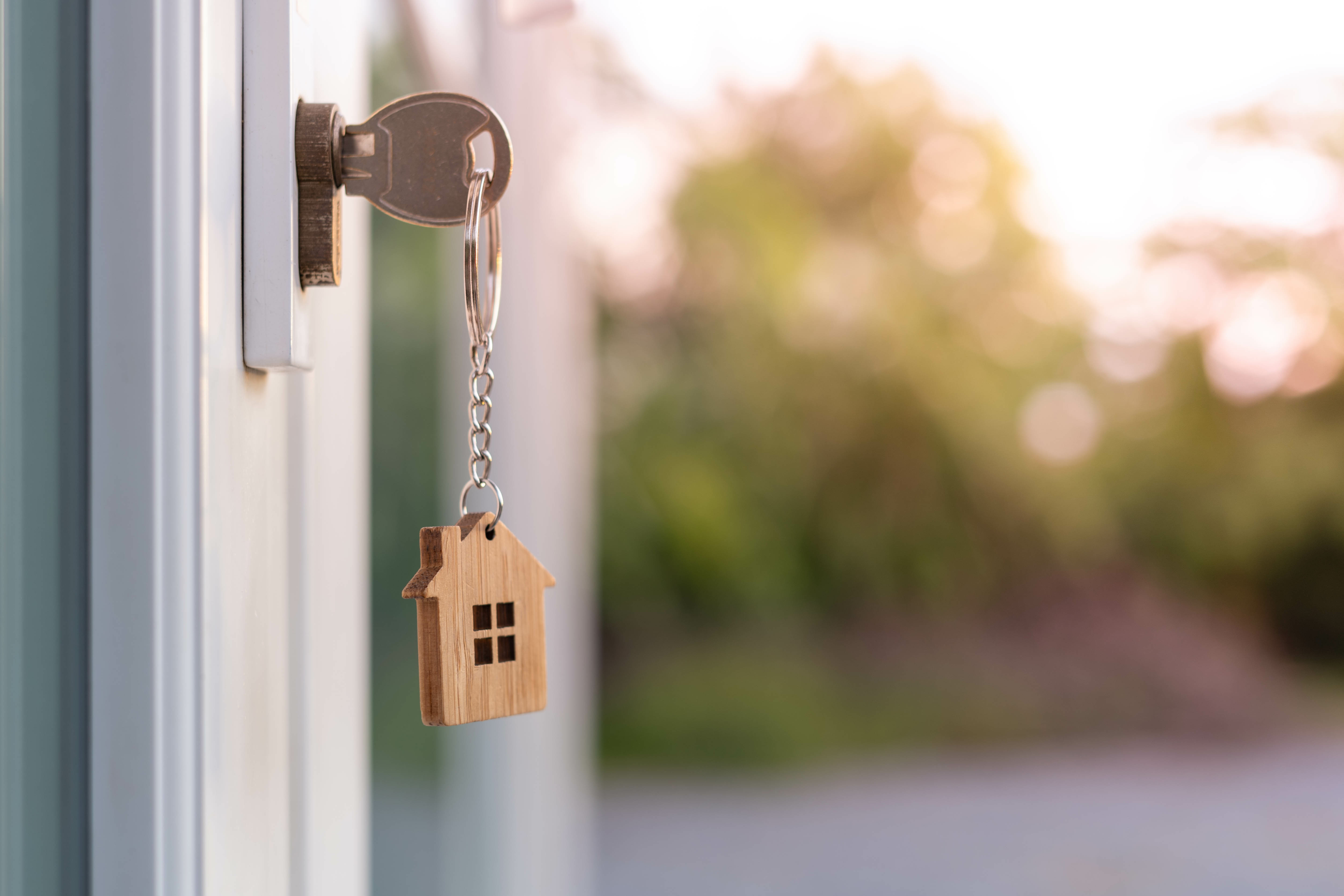 The house key is inserted in front of the door and opens to welcome the new owner. 