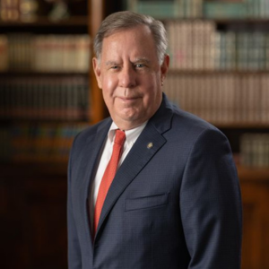 headshot of a man standing in a boardroom