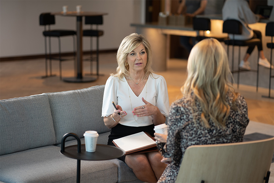 Two professional women talking at a coffee shop