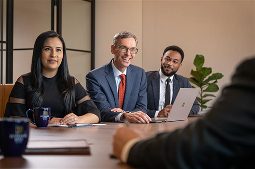 Team of trust advisors meeting with a client sitting across a boardroom table