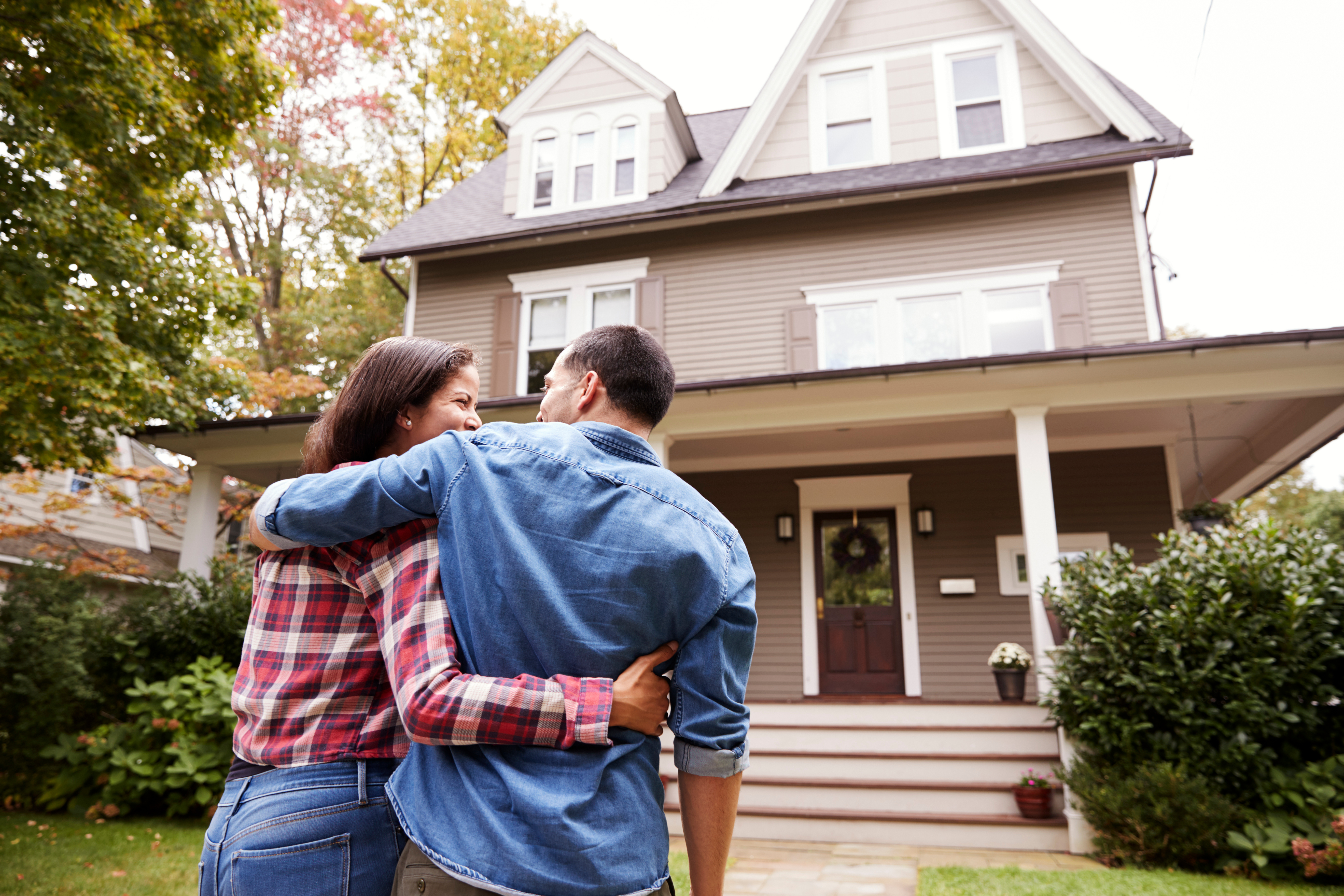 Couple standing in front of their new home