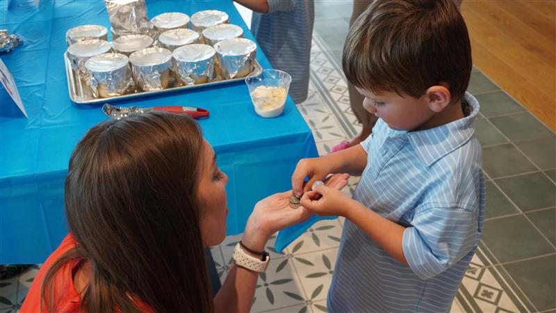 Child learning to count coins during financial literacy activity