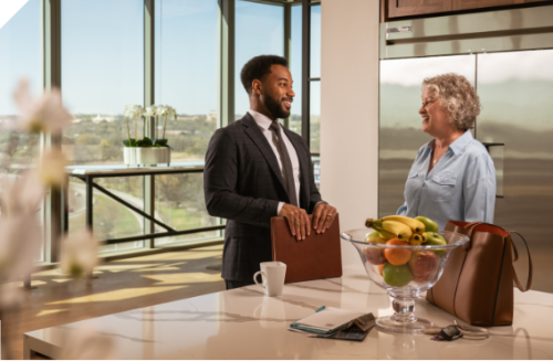 Banker and Woman having conversation in her kitchen.