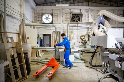 Worker using a pallet jack in a warehouse. 