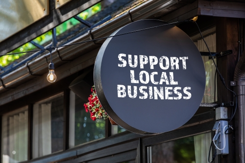 A circular sign that reads "support local business" in all caps. 