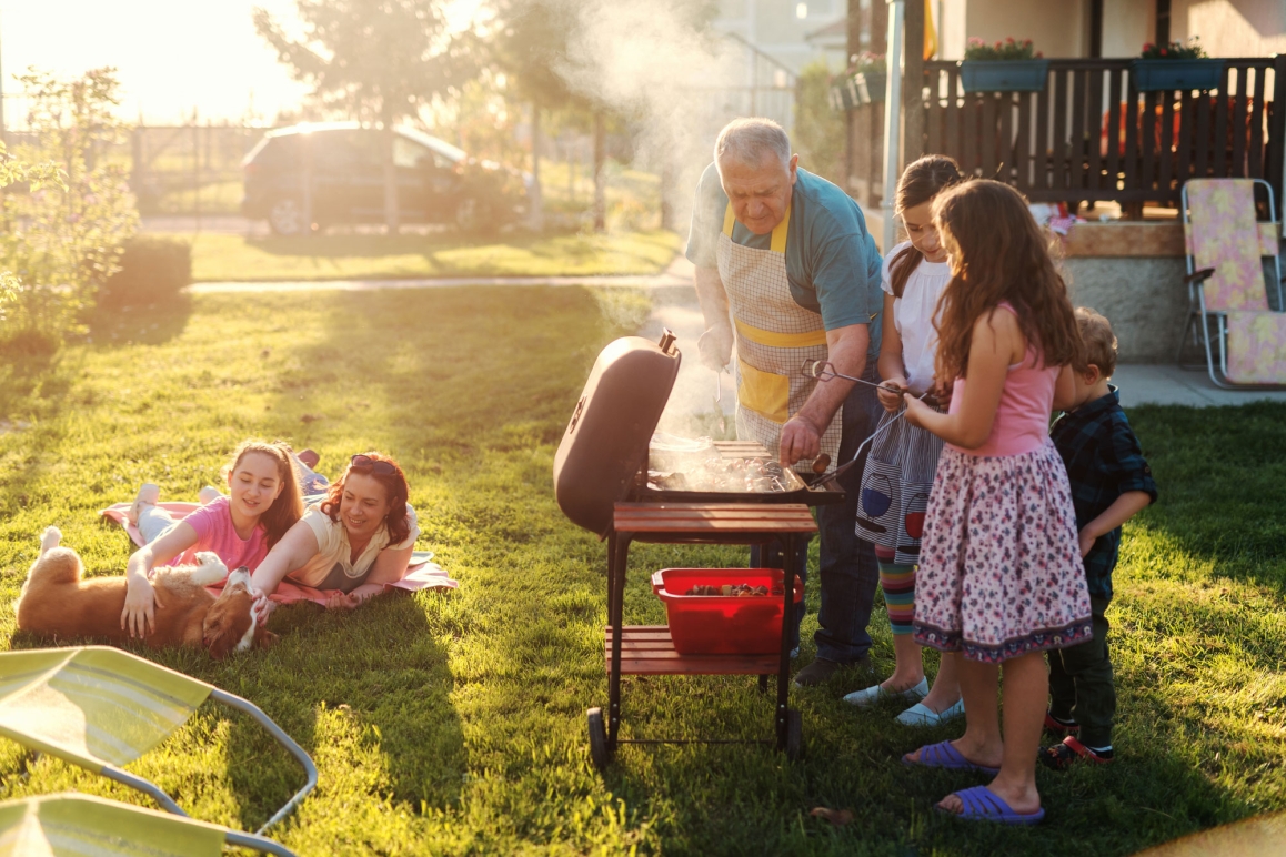A family grilling in their home's front yard. 