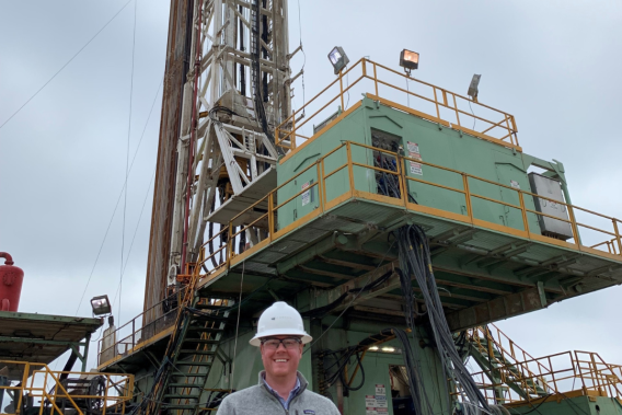 Man standing in front of an oil rig