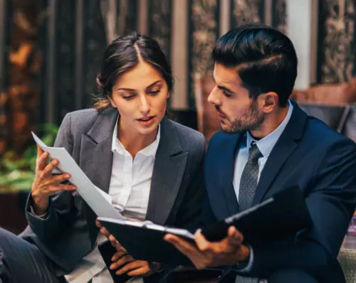 Man and Woman dicussing a portfolio.